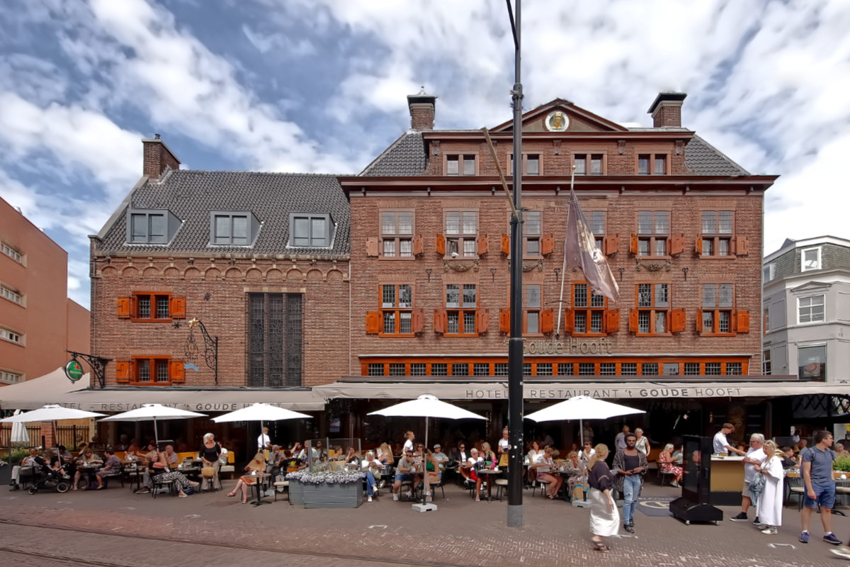 Mensen zitten op het terras van het Goude Hooft zonder te beseffen wat er onder hen zich heeft afgespeeld